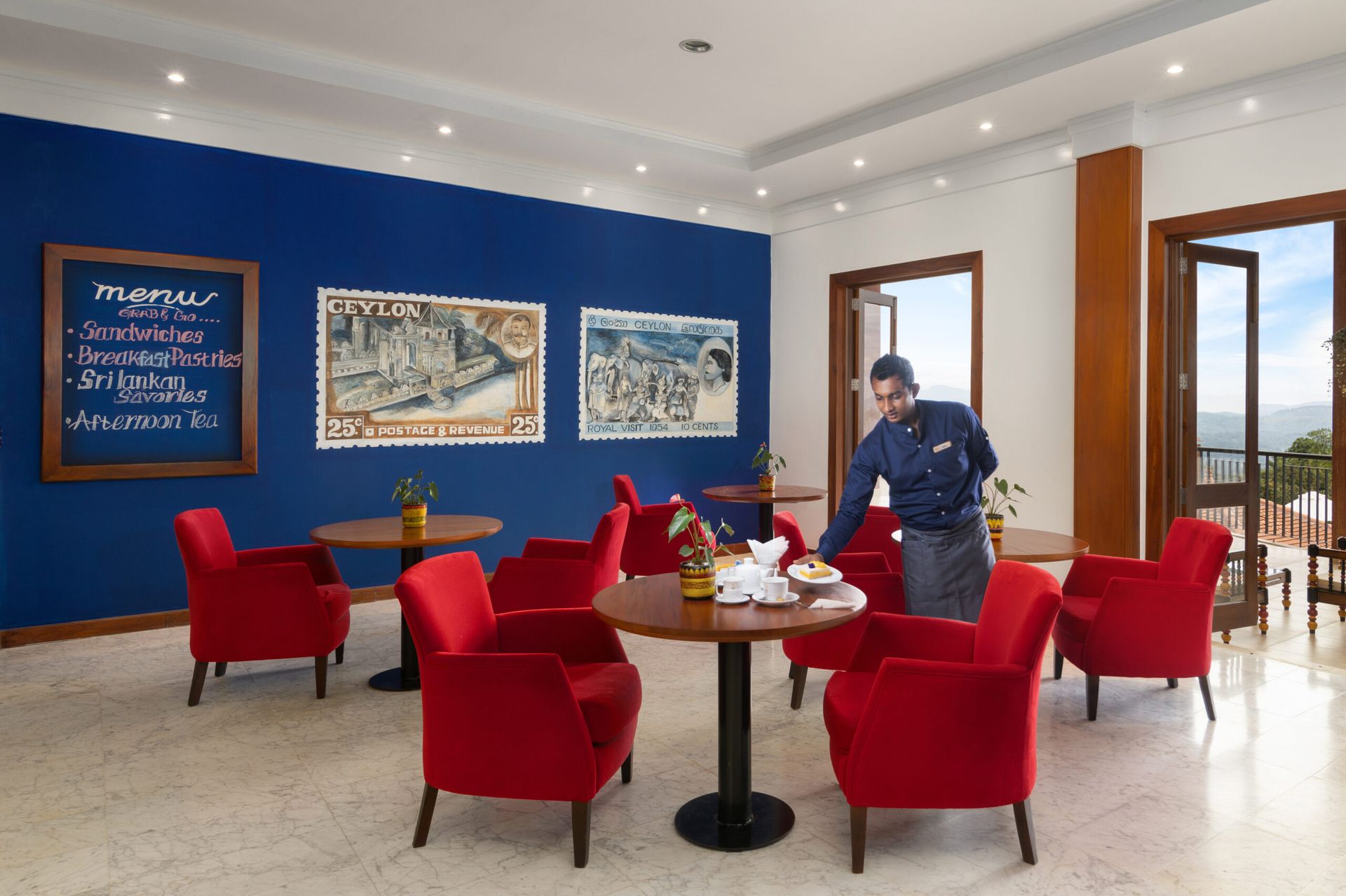 A staff member serving tea and snacks at Sangraha, Amaya Hills Kandy