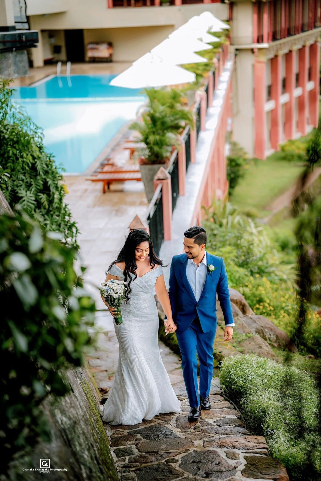 Newlyweds walking outside near swimming pool