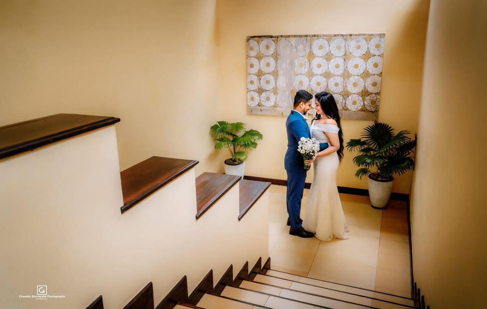 Newlywed couple posing indoors near staircase