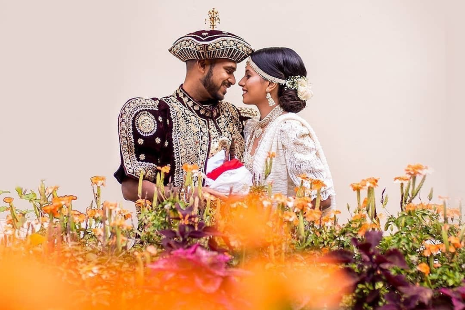 A couple dressed in traditional Sri Lankan wedding attire 