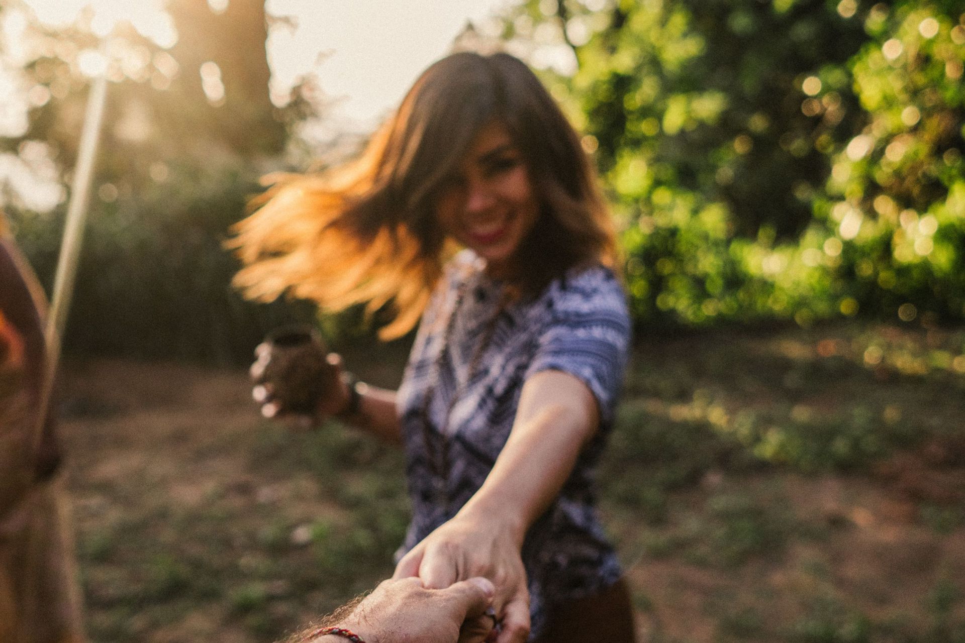 A woman smiling while her hand is held and picture is taken 