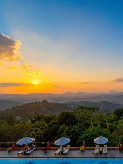 Sunset over hills from a scenic poolside balcony view at Amaya Hills Kandy