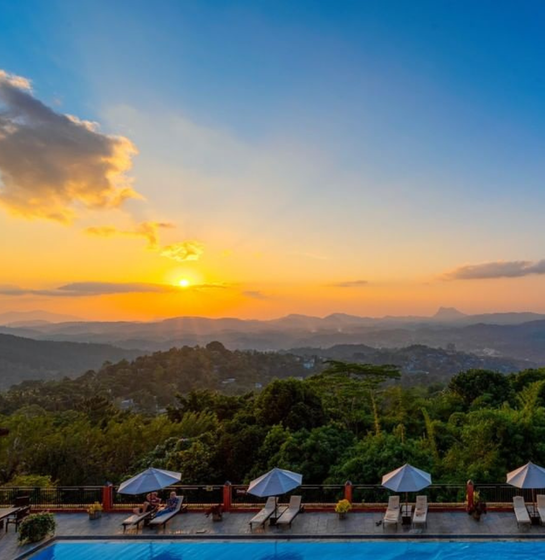 Sunset over hills from a scenic poolside balcony view at Amaya Hills Kandy