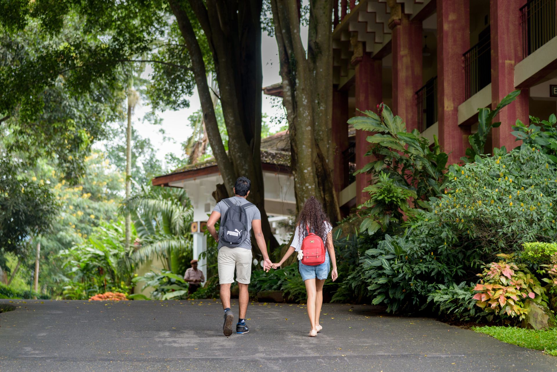 A couple carrying backpacks and holding hands
