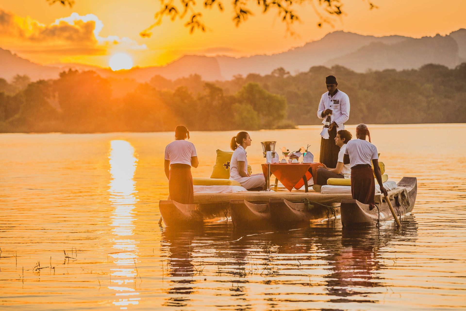 A couple being served drinks atop a traditional boat